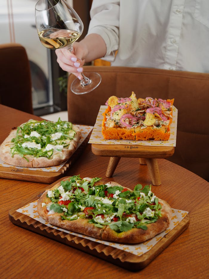 about-us-02 Delicious Italian flatbreads served with a glass of white wine, perfect for dining.