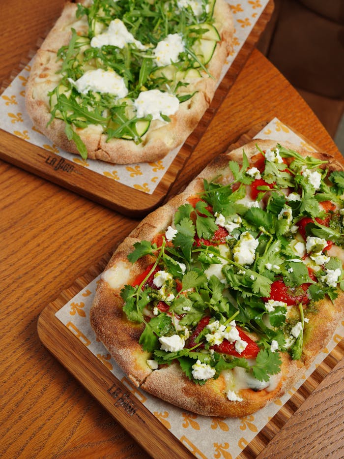 about-us-01 Delicious Italian flatbreads with fresh arugula and ricotta on wooden boards.